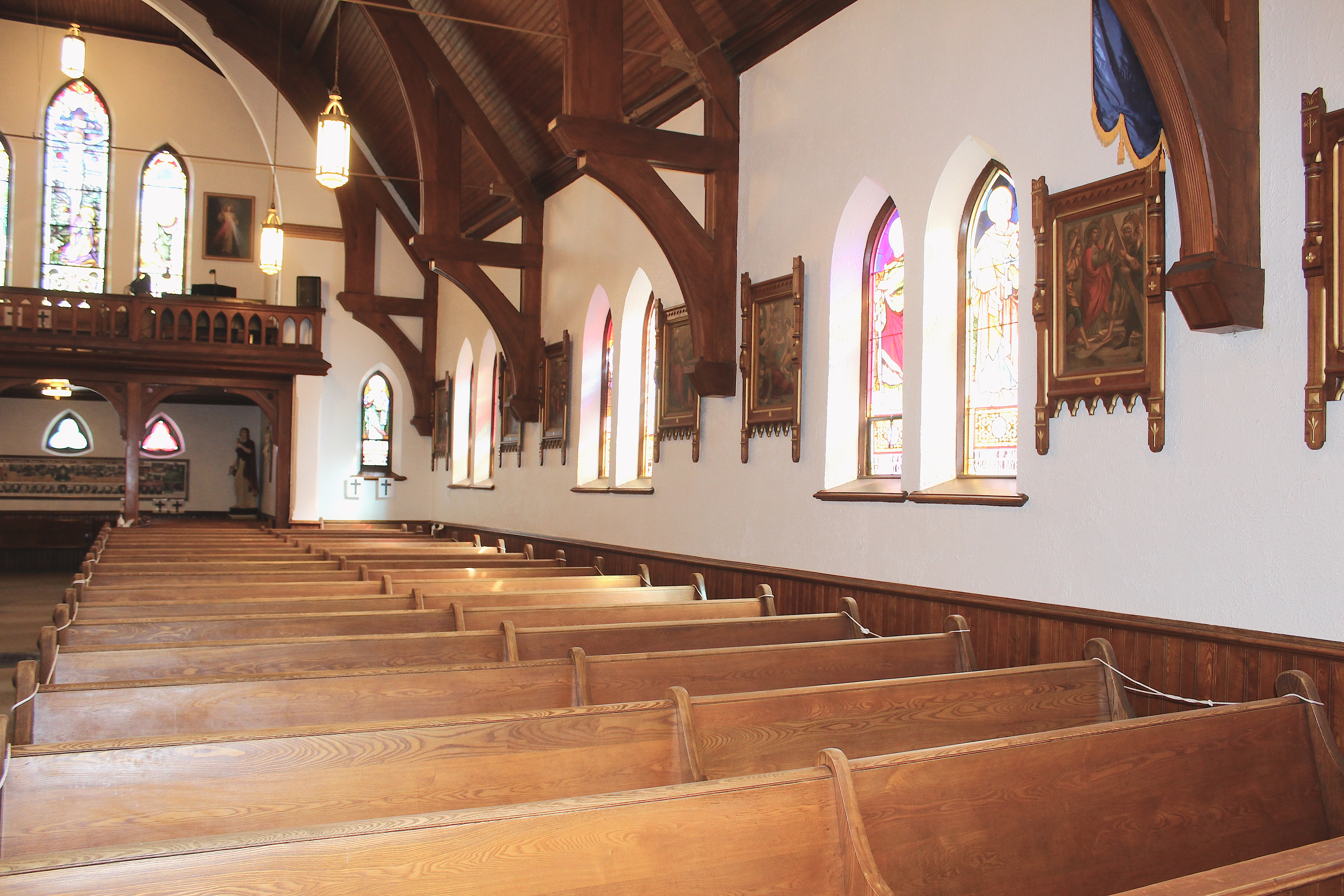 wood pews and windows on the right side of a church
