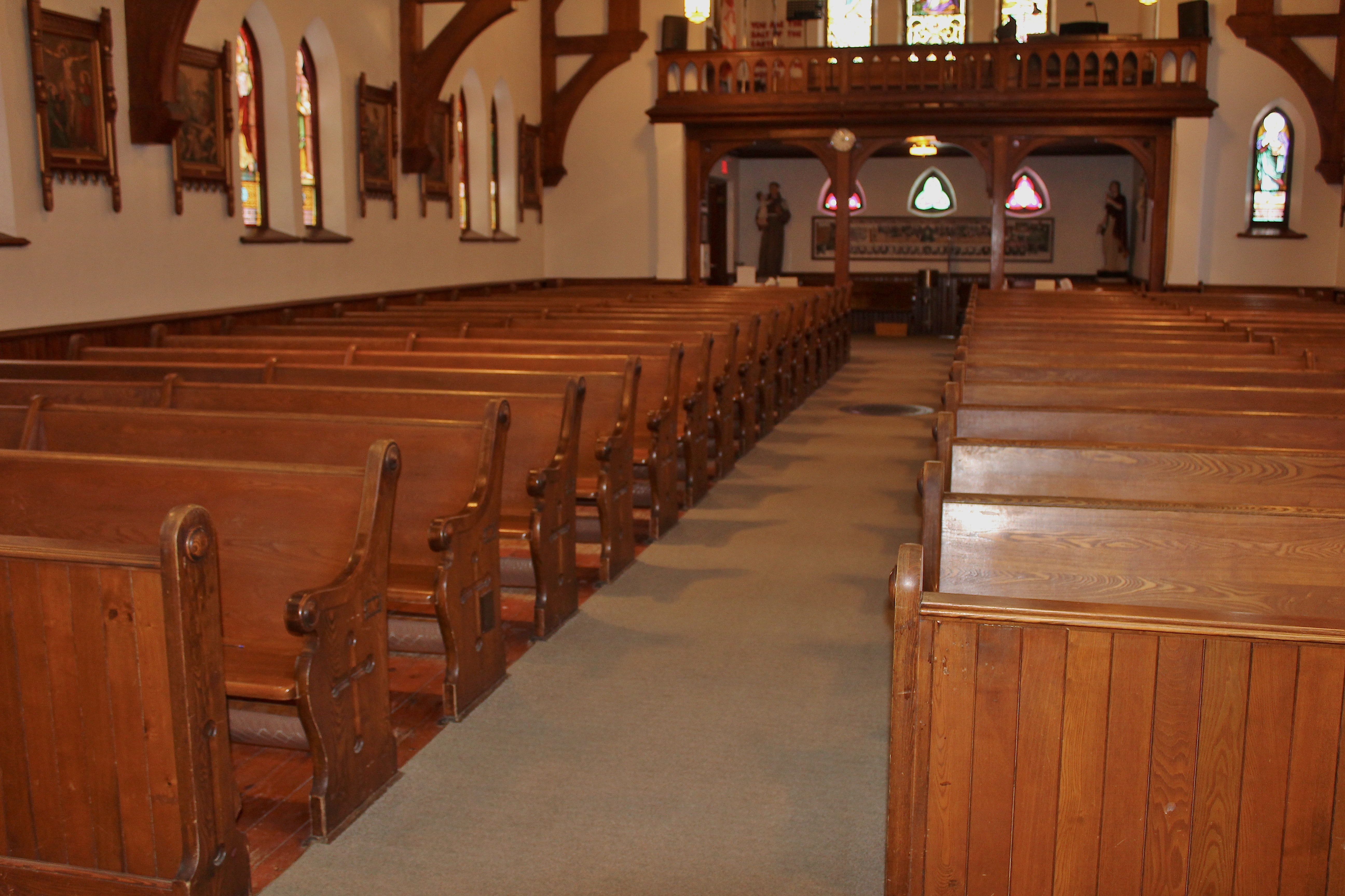 Wood church pews and windows in the left of a church